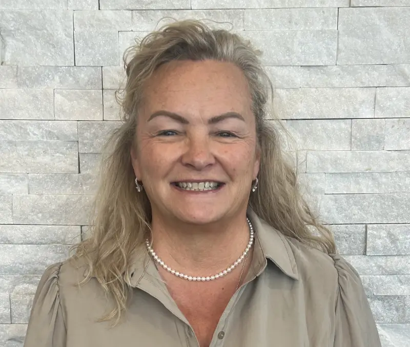 A woman with long hair and a brown shirt